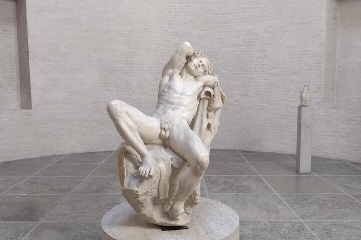 eine Statue eines Mannes, der von einem Felsen fällt
