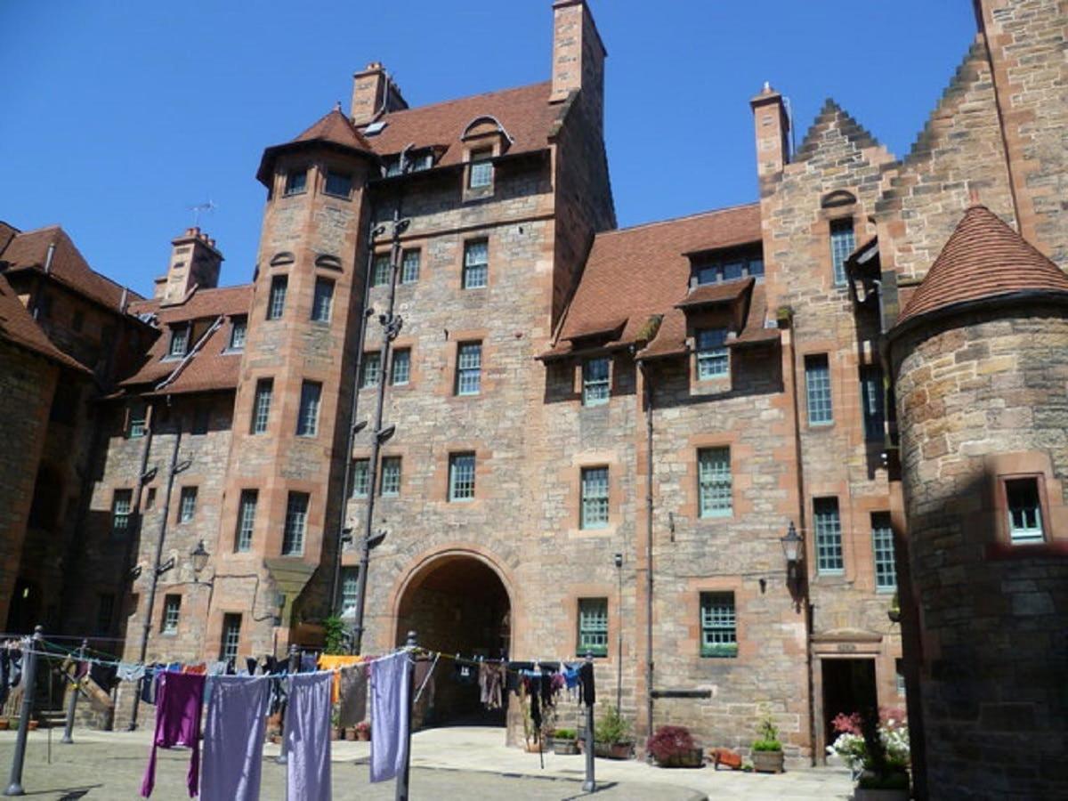 a large stone building with clothes drying on a line