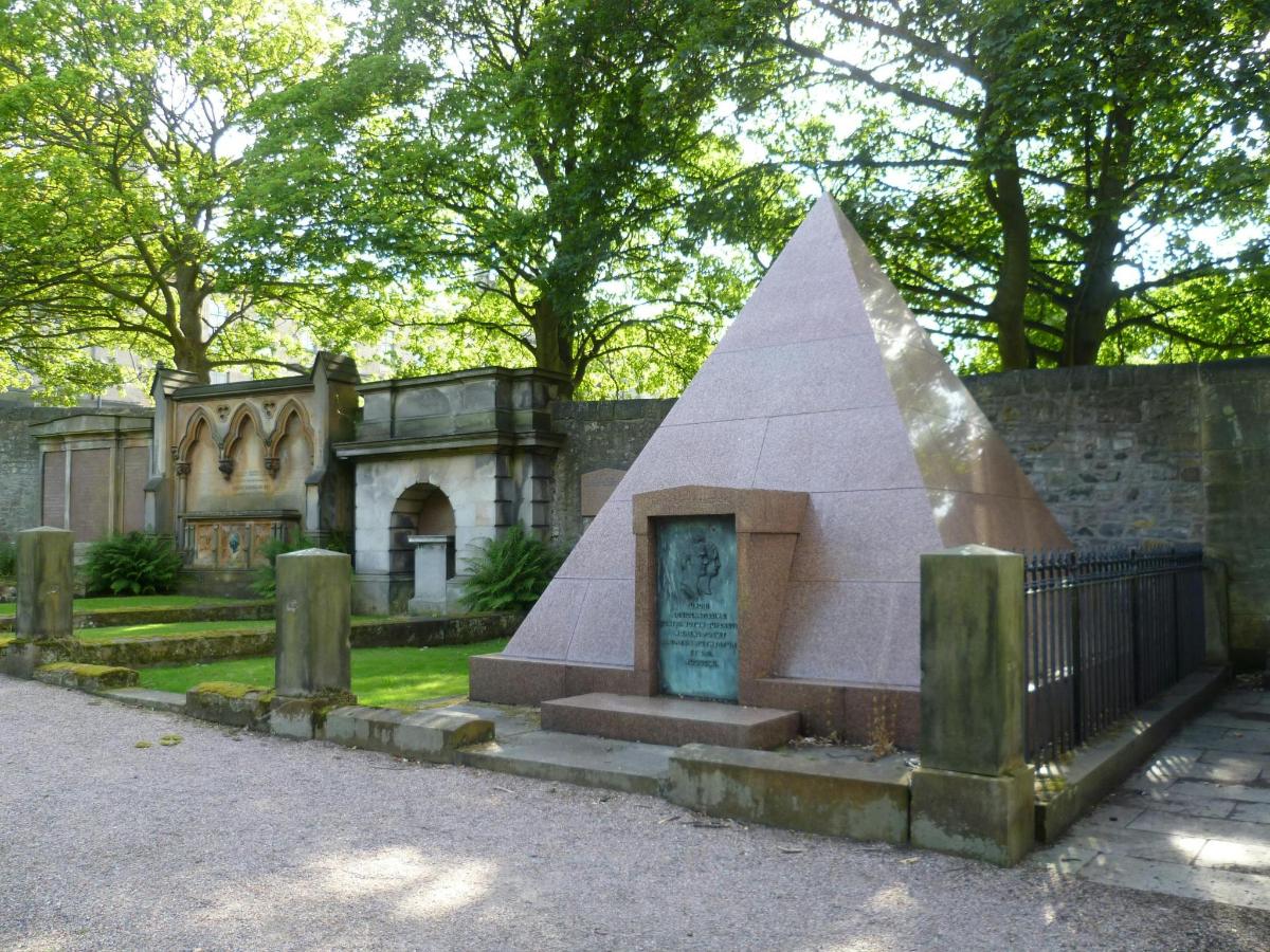a monument in front of a building with a pyramid
