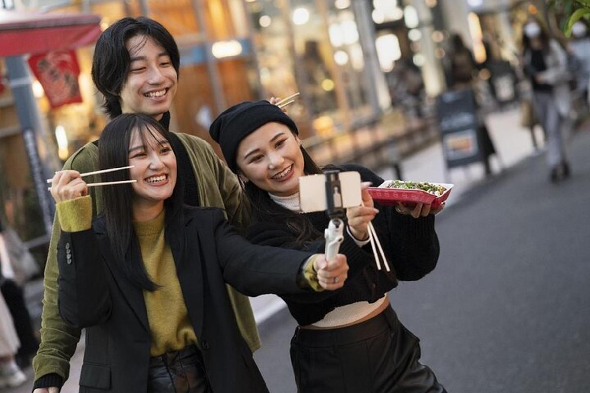 two women and a man posing for a picture with chopsticks