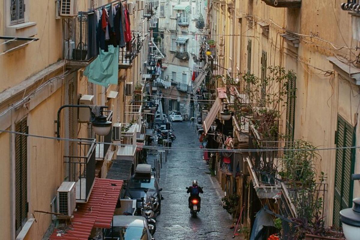 Ένας άντρας οδηγεί μοτοσικλέτα σε έναν δρόμο ανάμεσα σε κτίρια