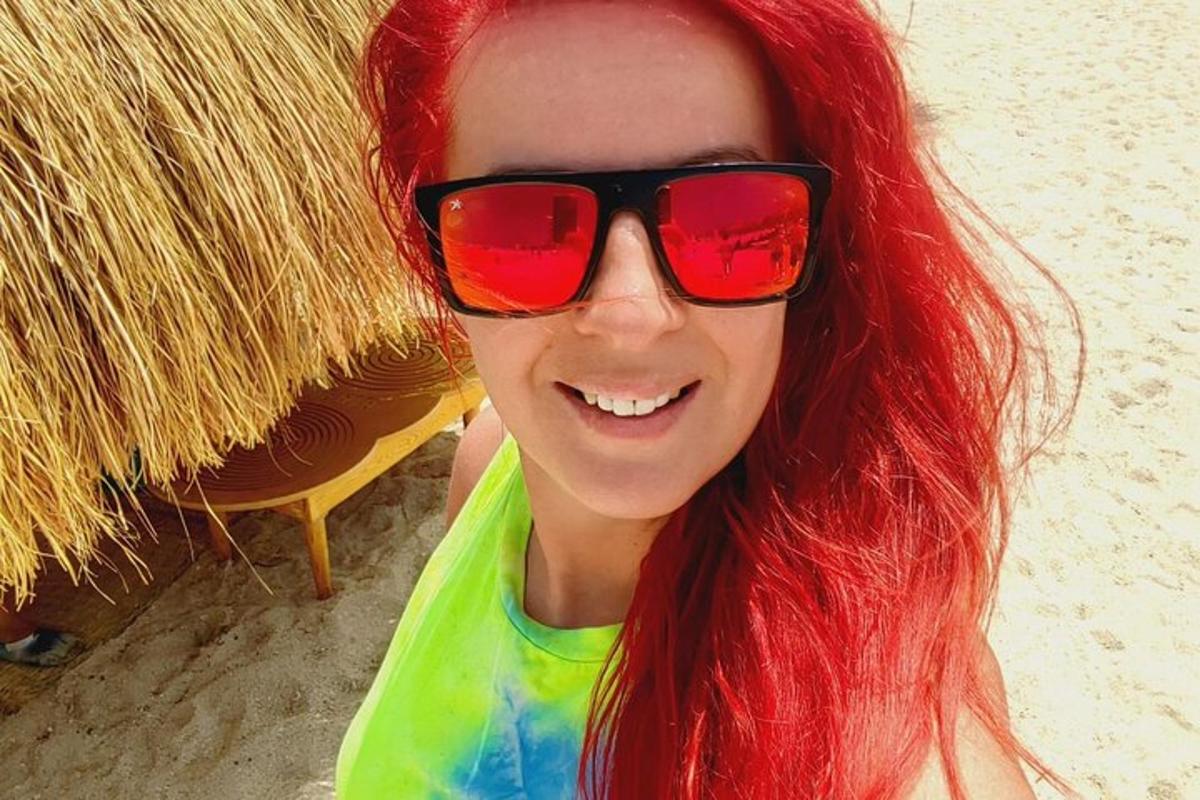 žena s rudými vlasy a slunečními brýlemi