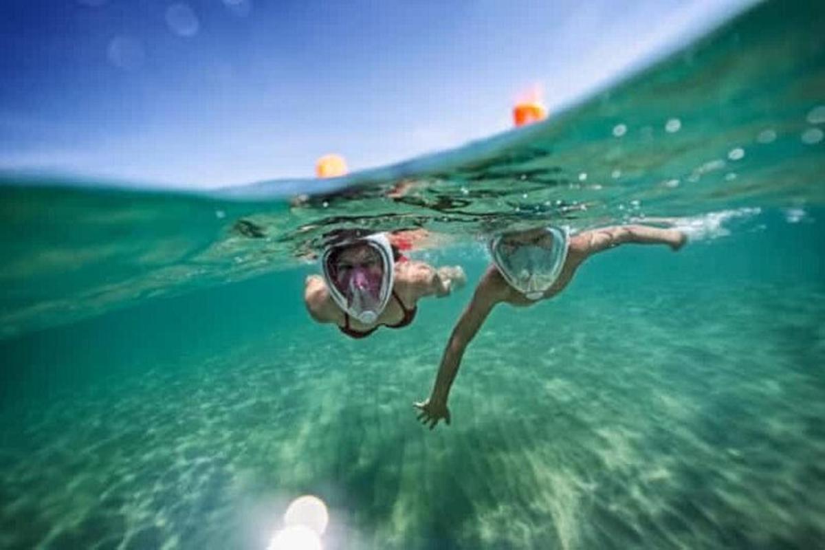una persona con maschera e occhiali che nuota nell'acqua