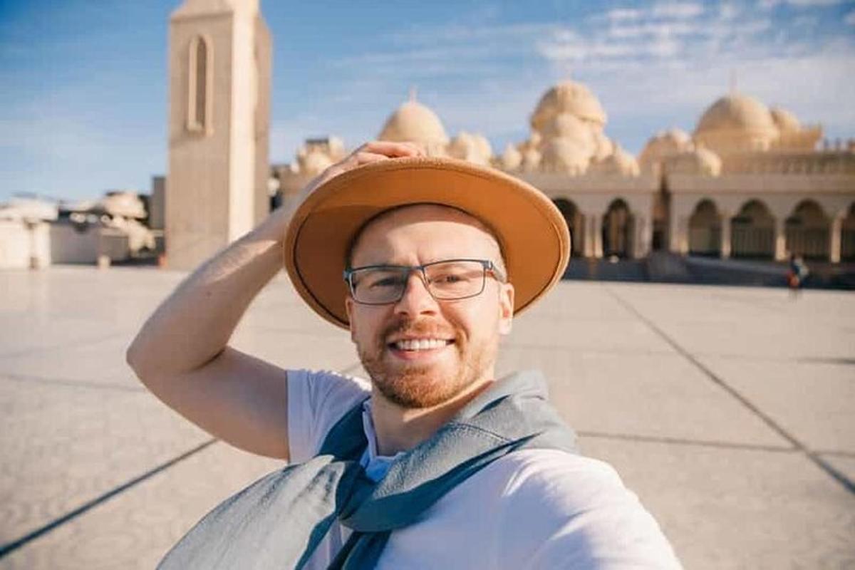 muž v klobouku před budovou