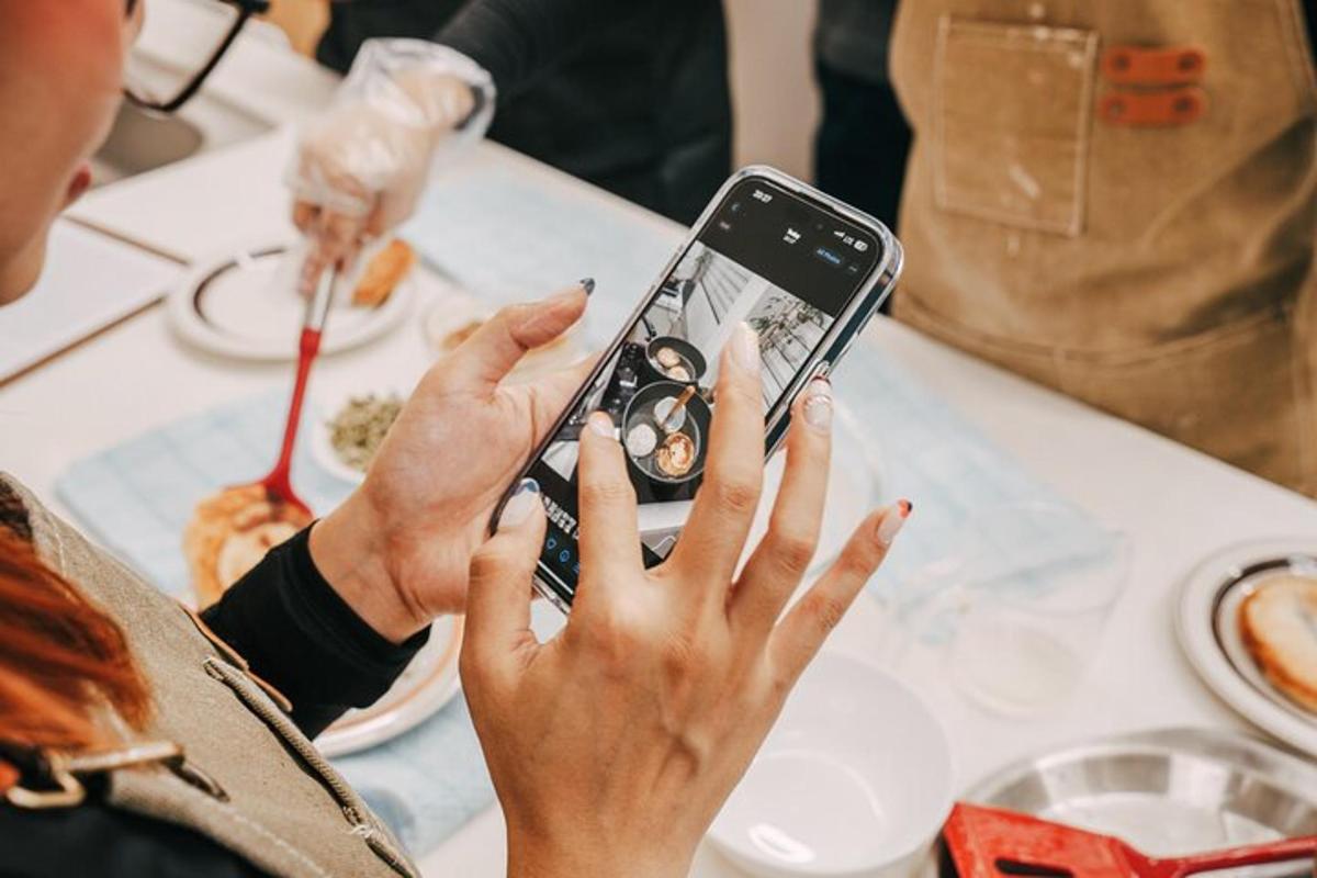 ženska, ki drži mobilni telefon, da bi fotografirala