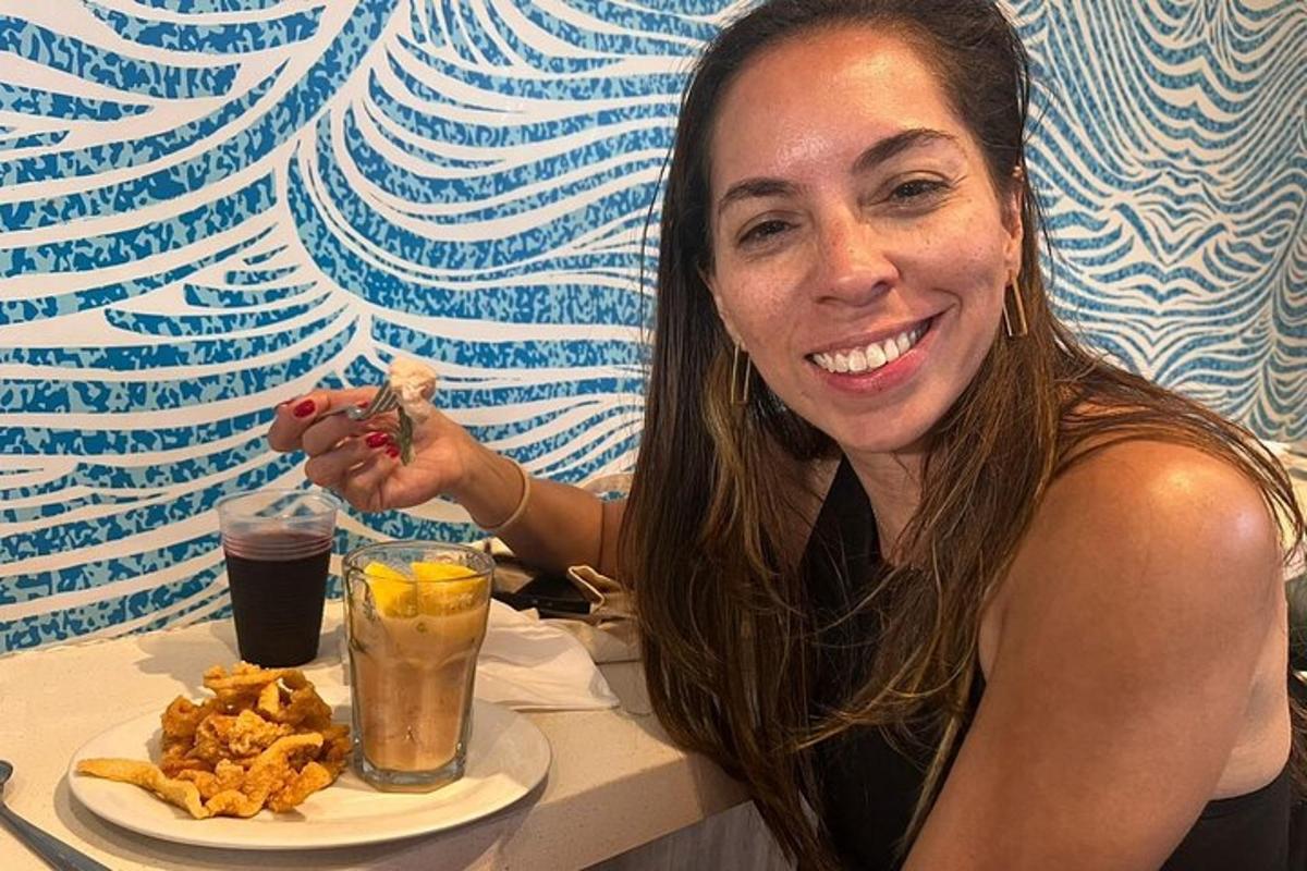 een vrouw die aan een tafel zit met een bord eten