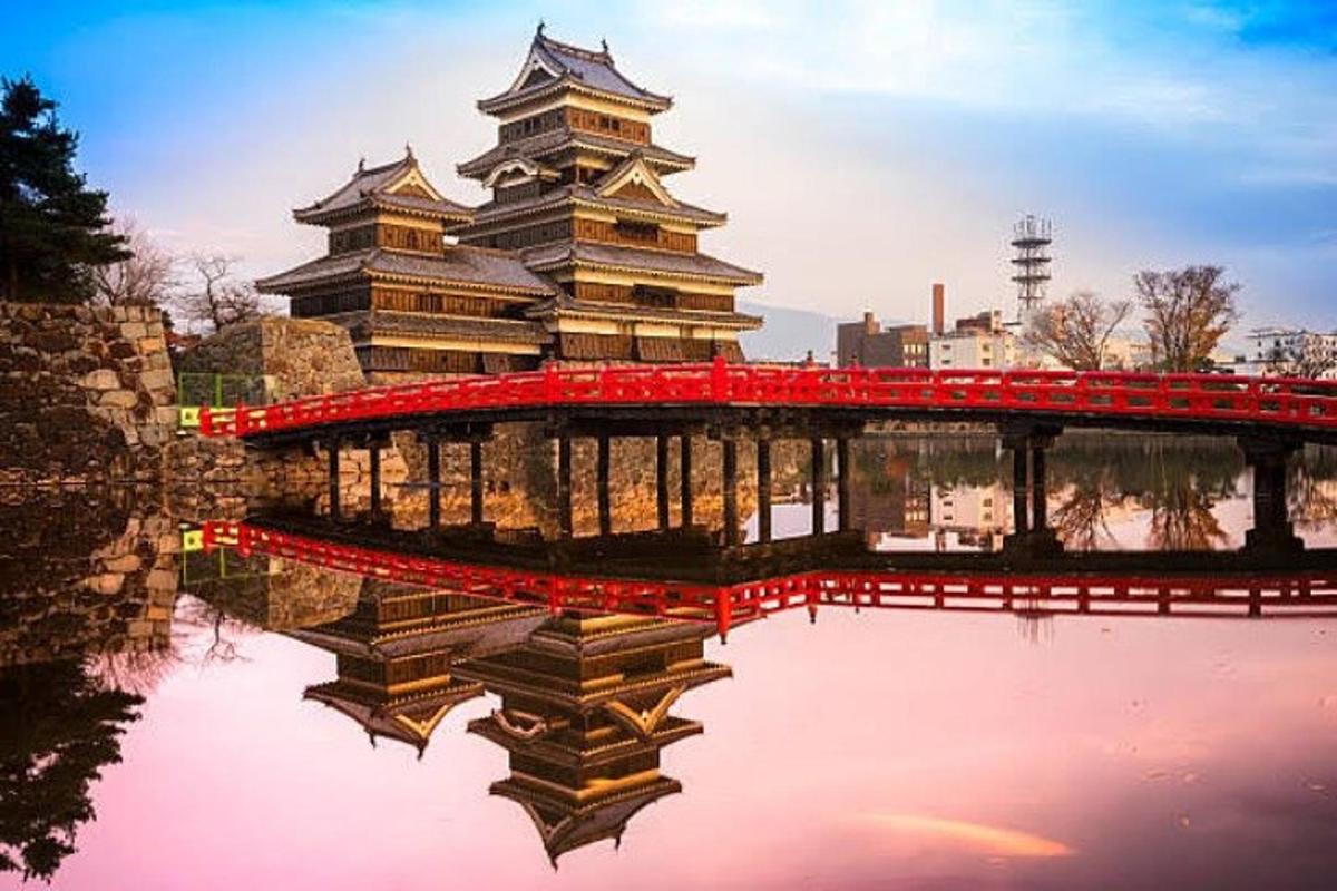 un grande edificio con un ponte sopra uno specchio d'acqua