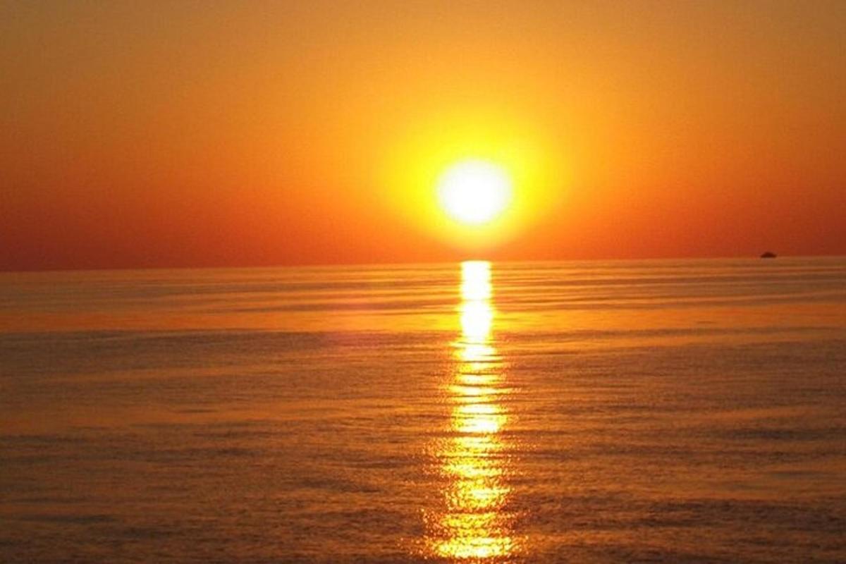 un tramonto sull'oceano con il sole che tramonta