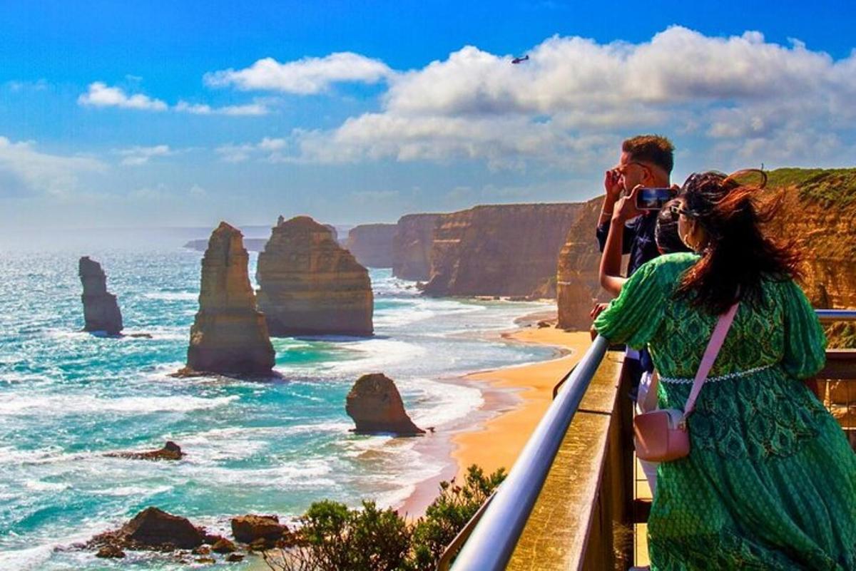 un uomo e una donna che scattano una foto dell'oceano e dei dodici apostoli