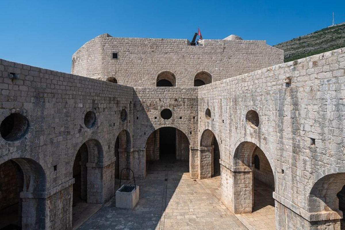 un grande edificio in mattoni con archi e una bandiera in cima