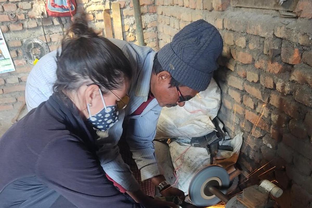 một người đàn ông và một người phụ nữ đang làm việc trên một máy nghiền