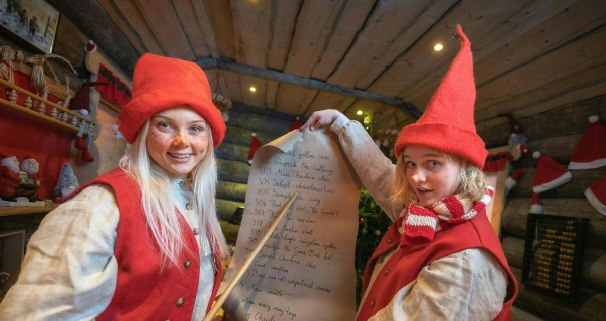 two women dressed up as gnomes holding a sign