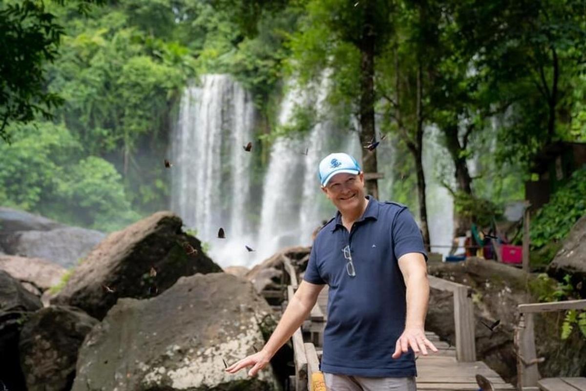 een man die voor een waterval staat