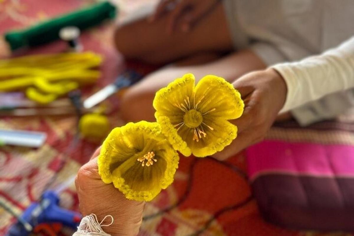 a person holding a yellow flower in their hand