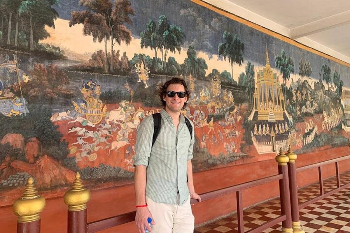 seorang lelaki berdiri di hadapan dinding dengan mural