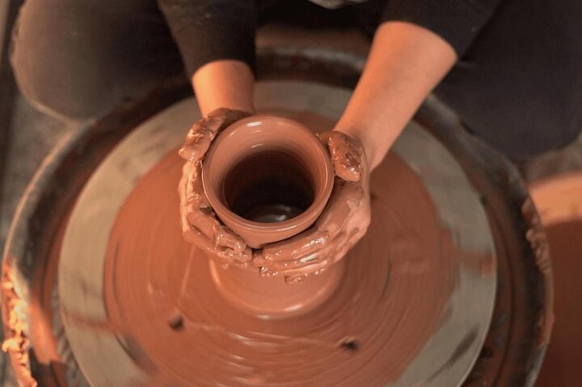 a person making a vase on a pottery wheel