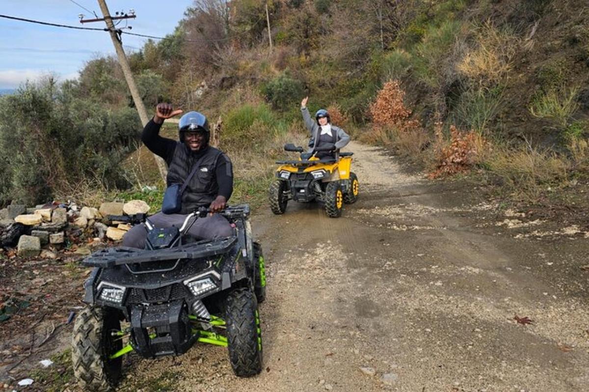 dues persones en quads per un camí de terra