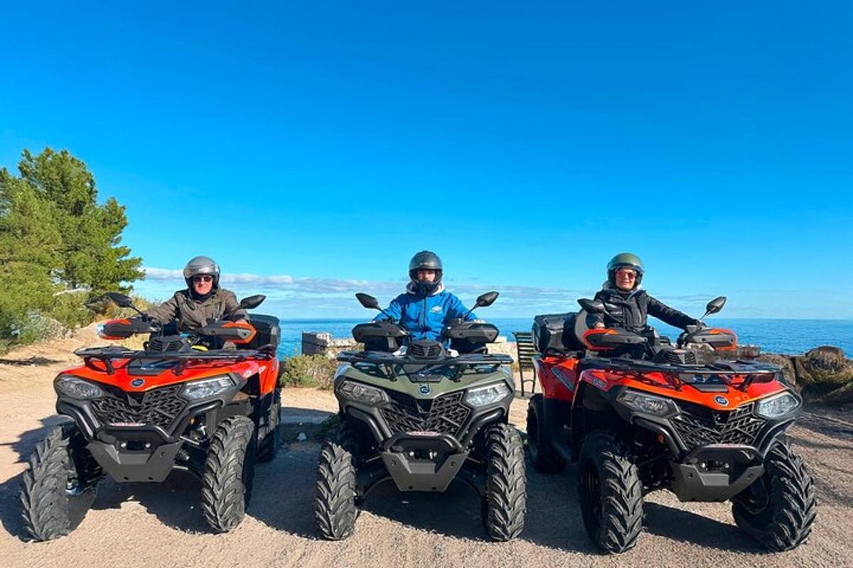 um grupo de três pessoas andando de quadriciclo em uma praia
