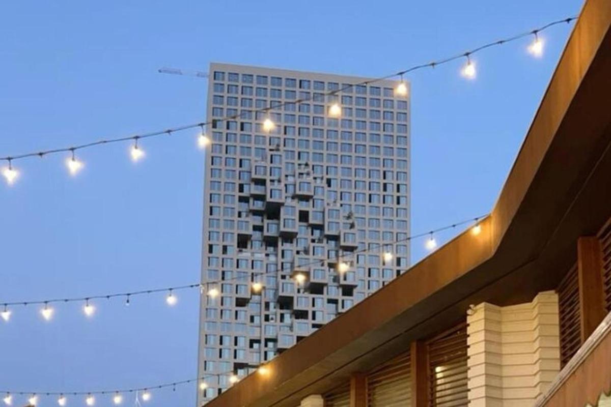 a tall building with lights in front of a building