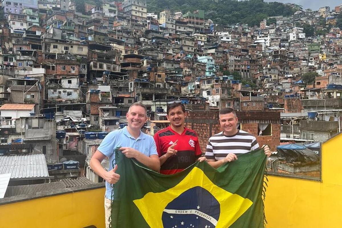 Tres hombres sosteniendo una bandera en lo alto de un edificio