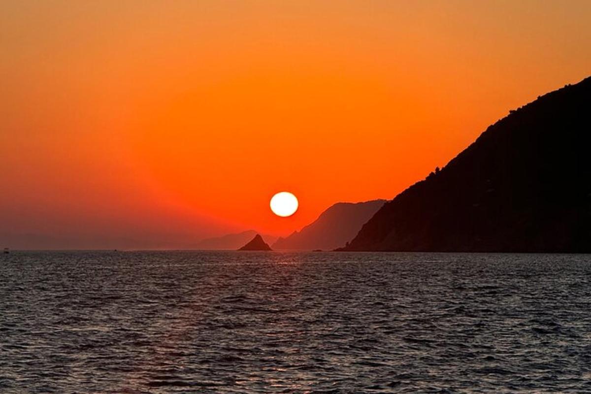 Západ slunce nad vodní plochou s horami