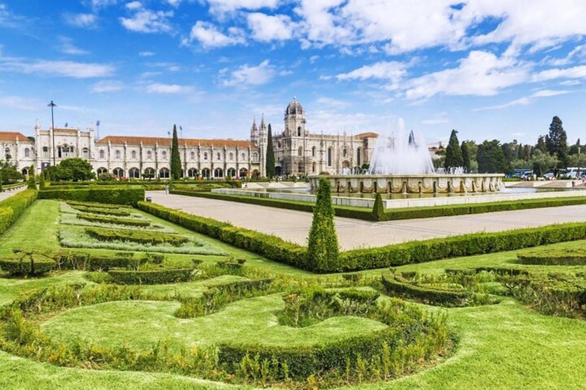 a garden in front of a large building with a fountain