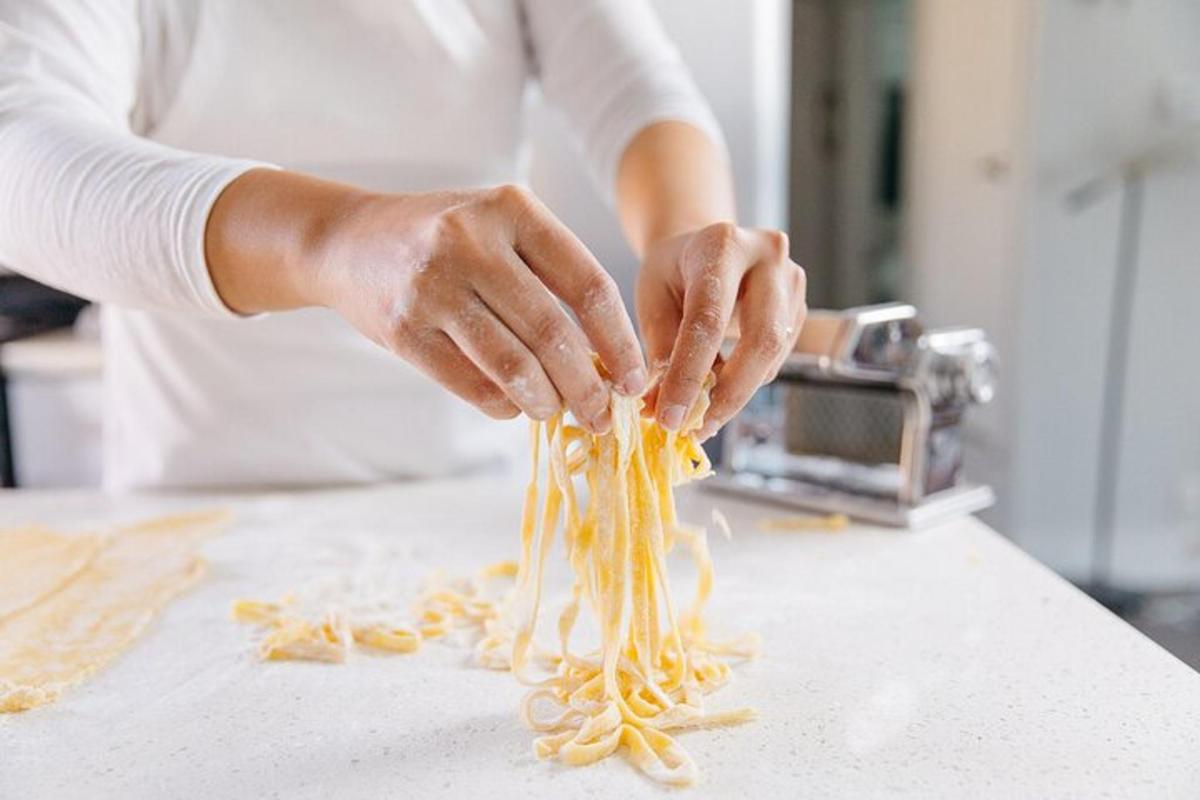 a woman is preparing pasta on a counter