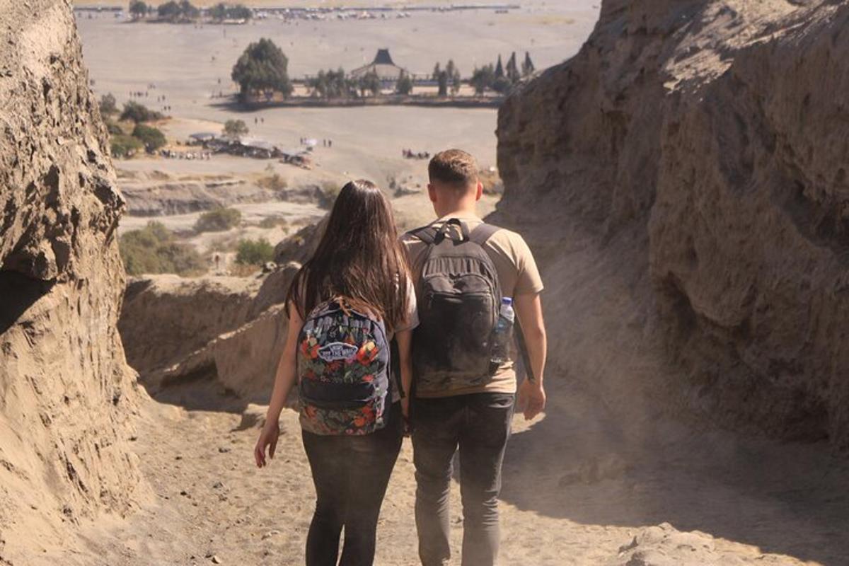a man and a woman walking down a dirt road