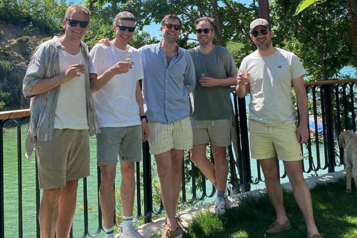 un gruppo di uomini in piedi davanti a una recinzione