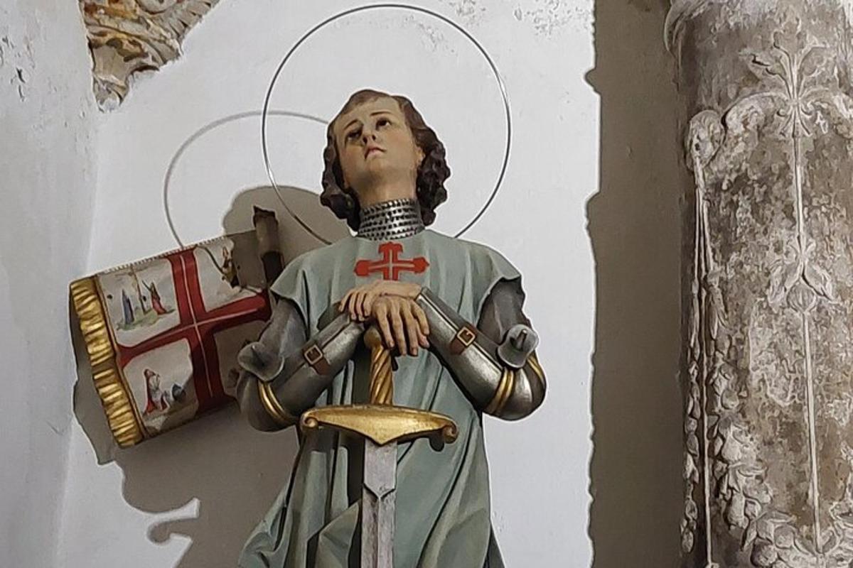 en statue af en jomfru, der holder en gylden skål