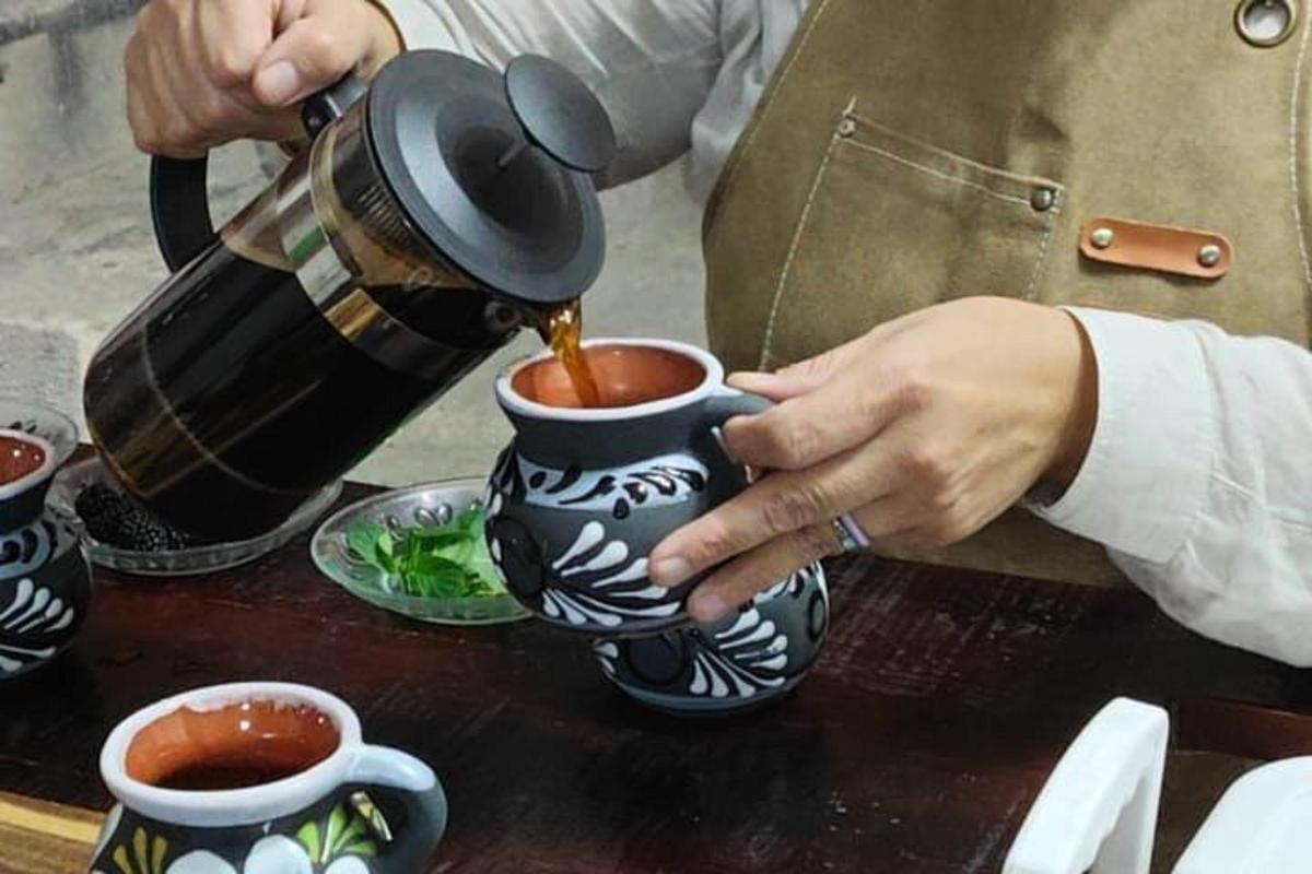 una persona sirviendo café en una taza sobre una mesa
