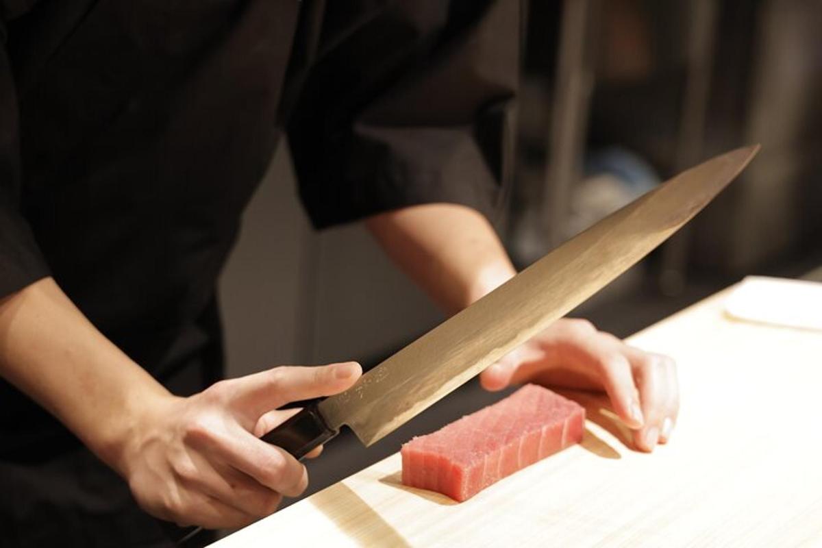 en person som skjærer et stykke vannmelon med en kniv