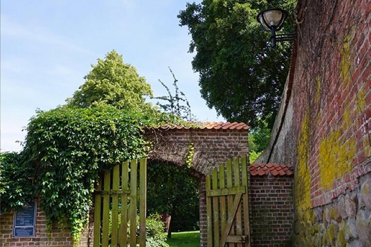 un ingresso a un muro di mattoni con un cancello di legno