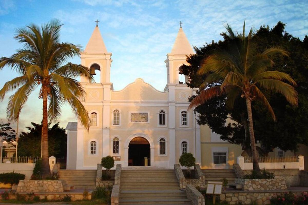 Una iglesia blanca con palmeras delante de ella.