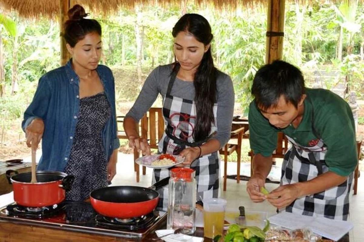 Un grupo de personas de pie alrededor de una estufa preparando comida.