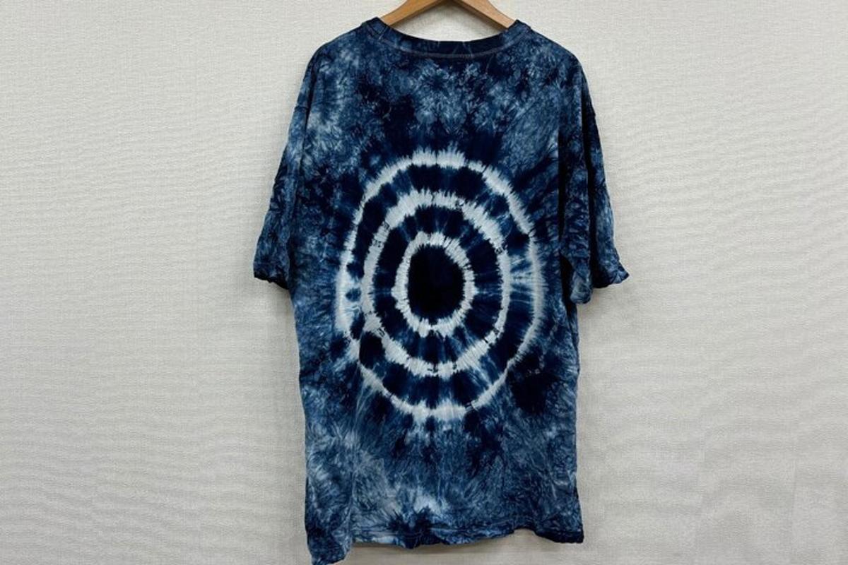 un vestit blau tenyit de tie-dye penjat a la paret
