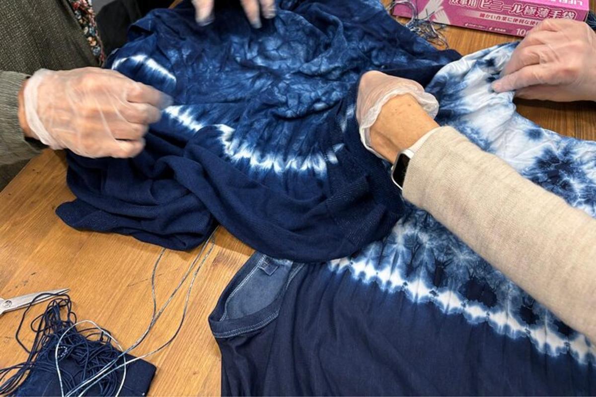uma pessoa trabalhando em uma camisa azul sobre uma mesa