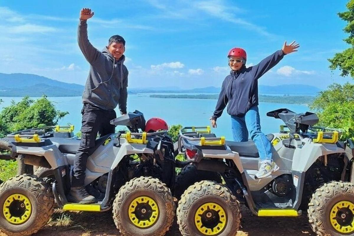 四輪バイクに乗って両手を挙げている二人の男性