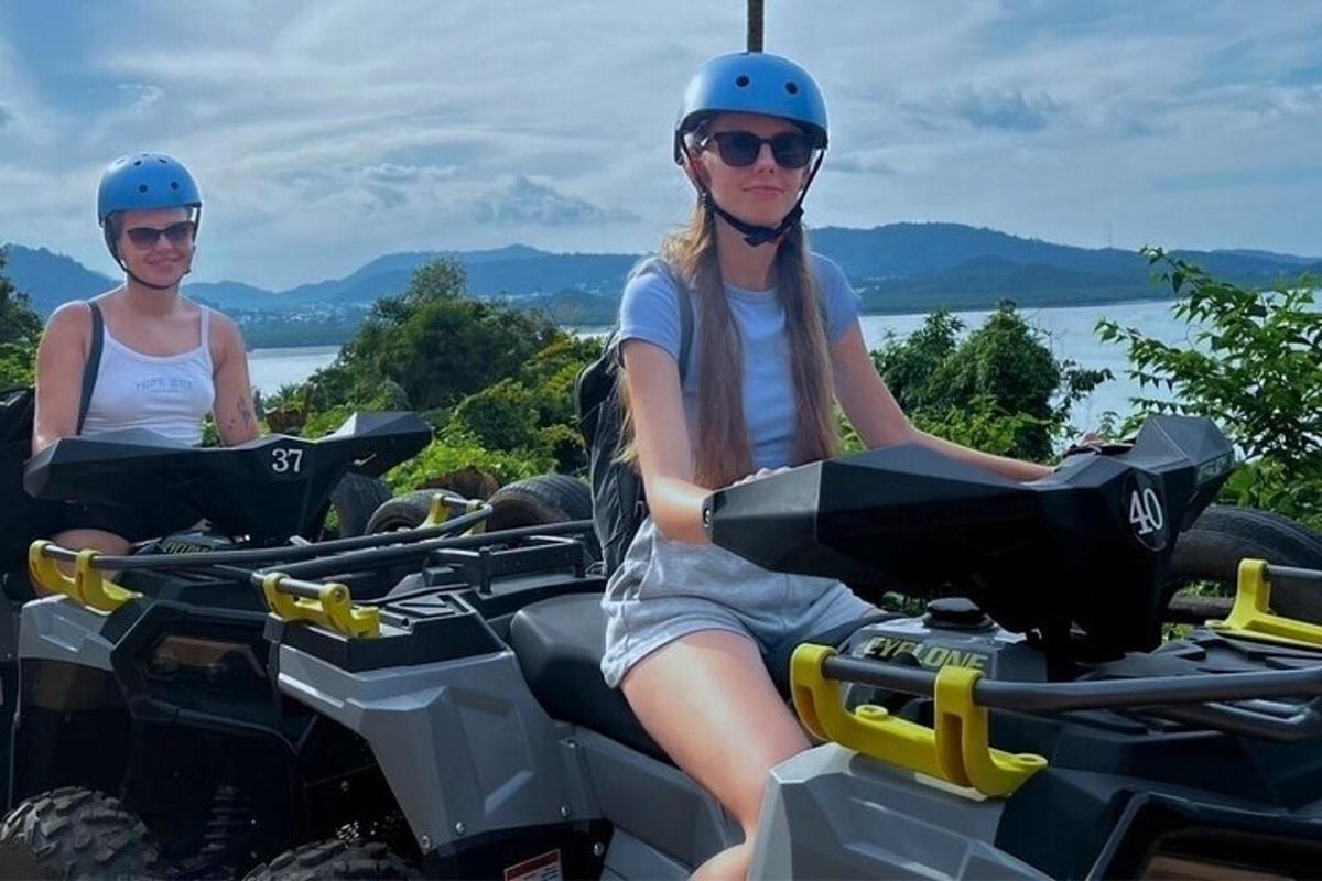 divas sievietes ķiverēs, braucot ar kvadracikliem