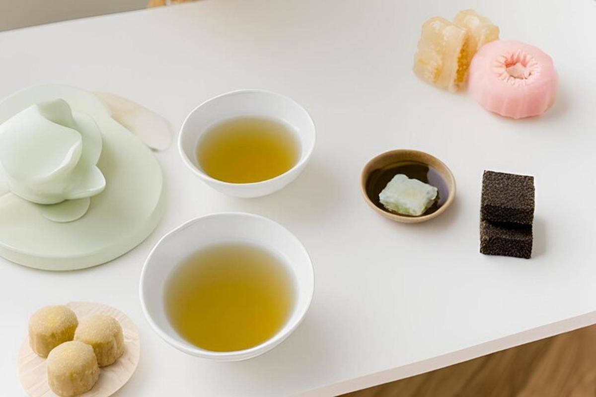 un tavolo bianco con due tazze di tè e sushi