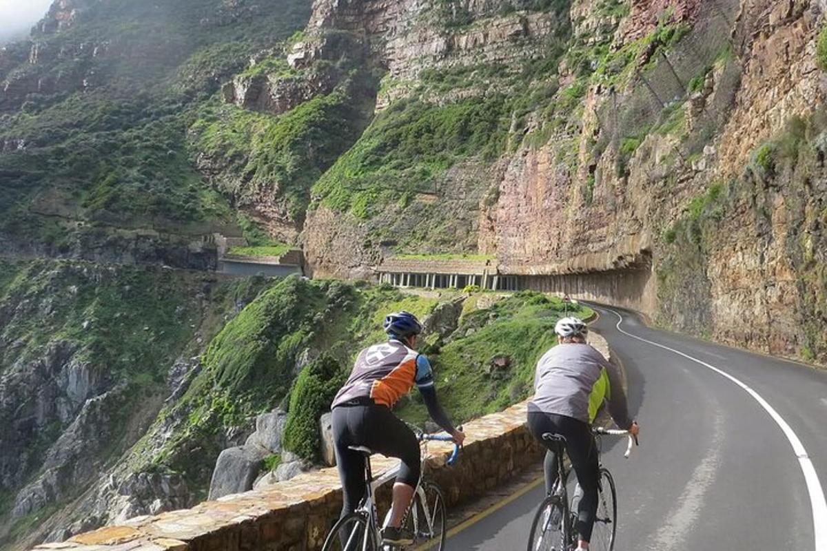 two people riding bikes on a mountain road