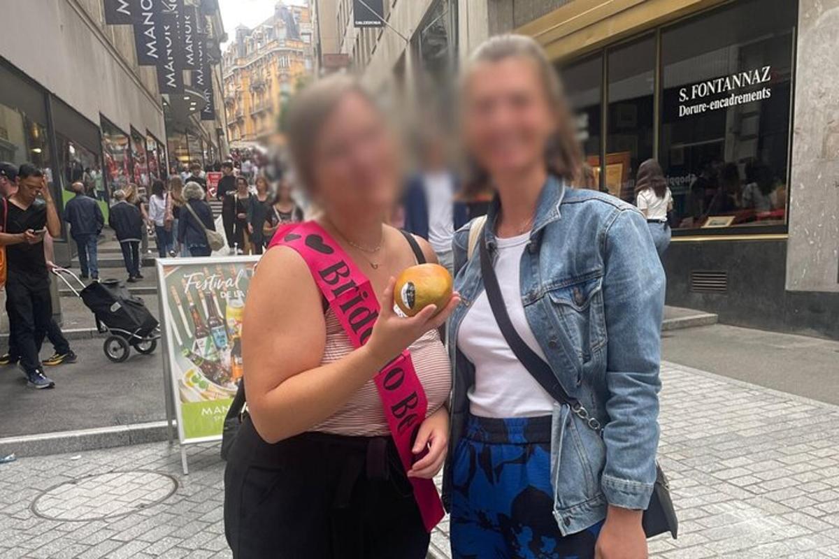 due donne in piedi su una strada cittadina con in mano un'arancia
