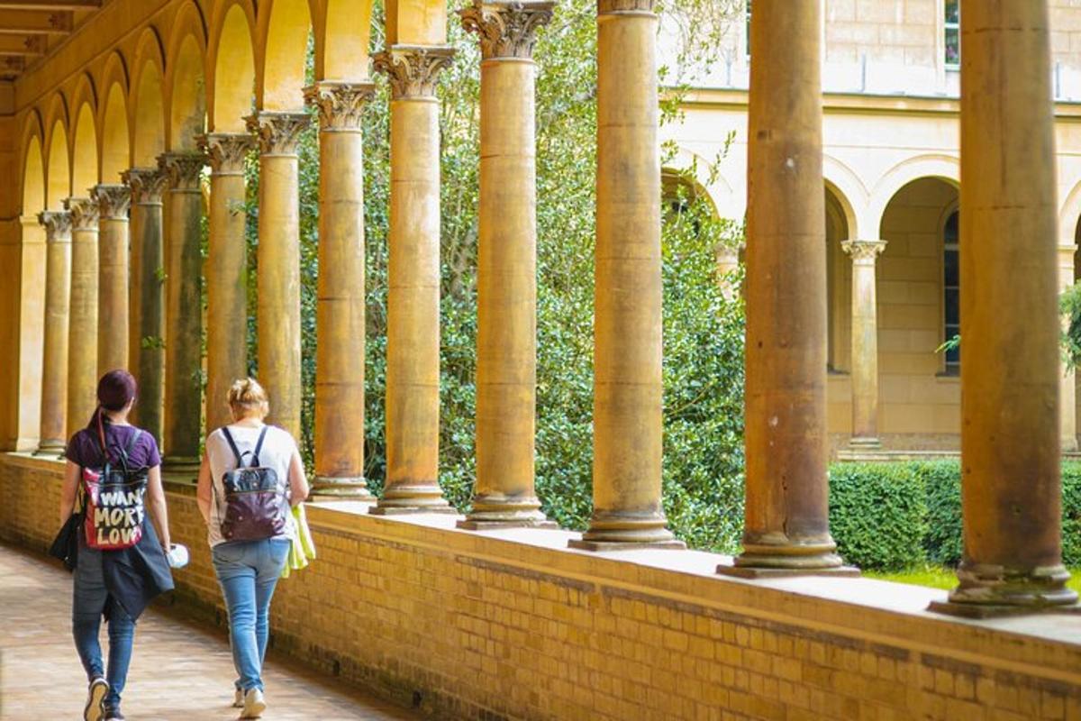 two women walking through a building with columns