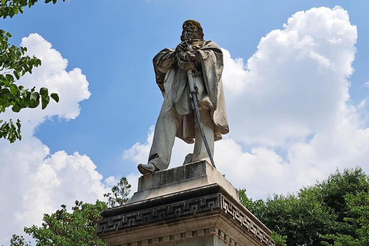 eine Statue eines Mannes, der auf einem Denkmal sitzt