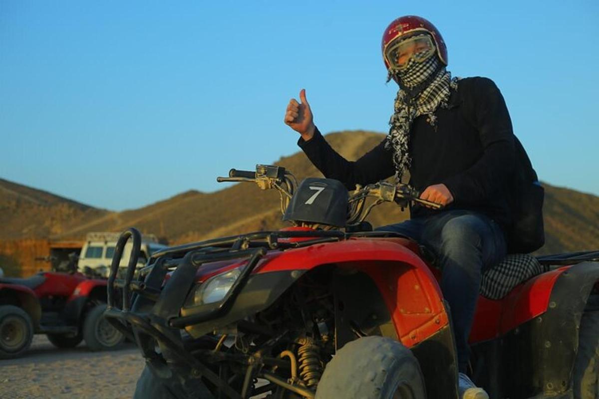 seorang lelaki berbasikal quad di padang pasir