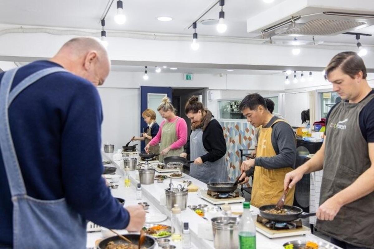 un gruppo di persone in piedi attorno a un tavolo che prepara il cibo