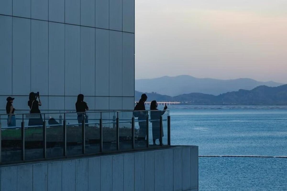a group of people walking on a building next to the water