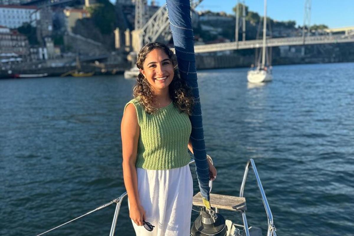 uma mulher em pé na frente de um barco na água
