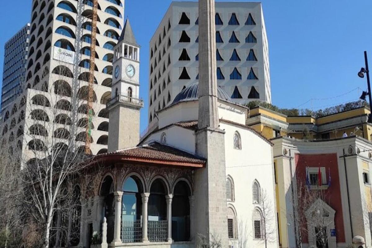 un edificio con una torre dell'orologio accanto a due edifici alti