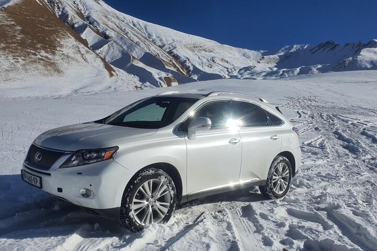 um carro branco está estacionado na neve